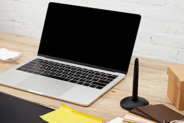 close up view of laptop, graphic tablet and pallet on wooden surface at graphic designer workplace